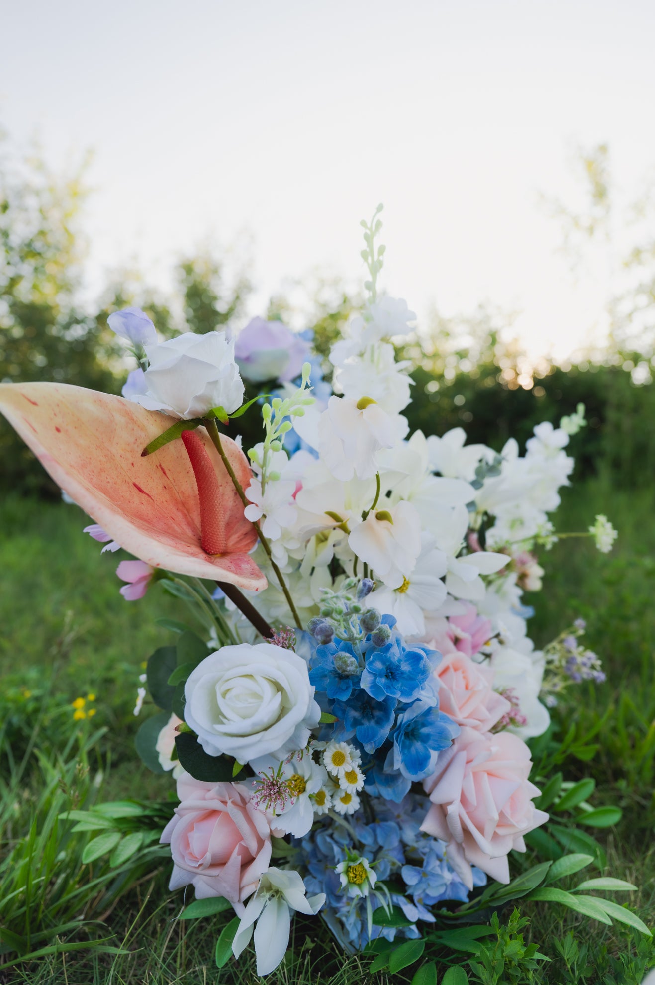 Close-up of artificial pastel wedding floor florals with blush roses, blue hydrangeas, and white daisies, available for Edmonton ceremony and reception decor rental.