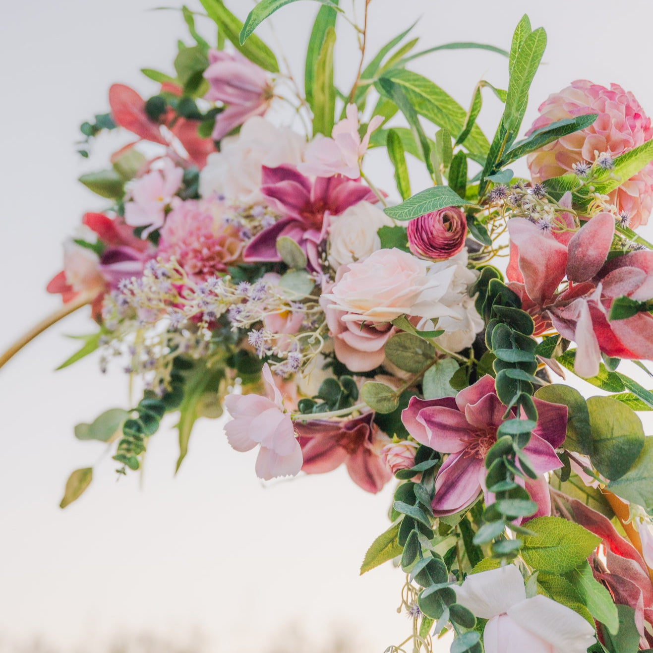 Floral arch with pink and white flowers against a blurred natural background