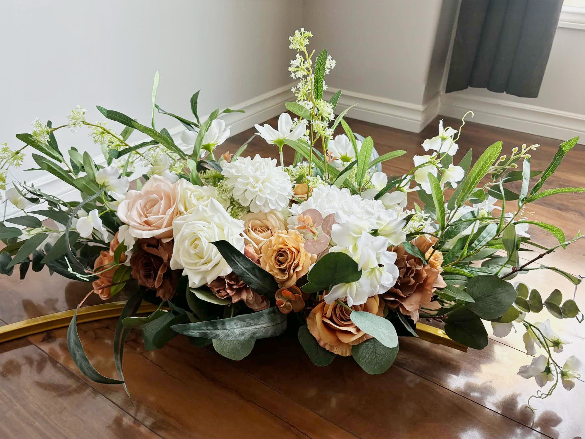 Close up of the brown floral arch on a wooden floor