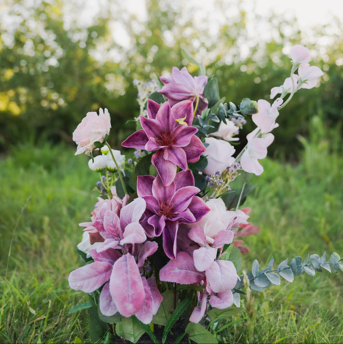 Bouquet of pink and purple flowers with greenery on a blurred natural background