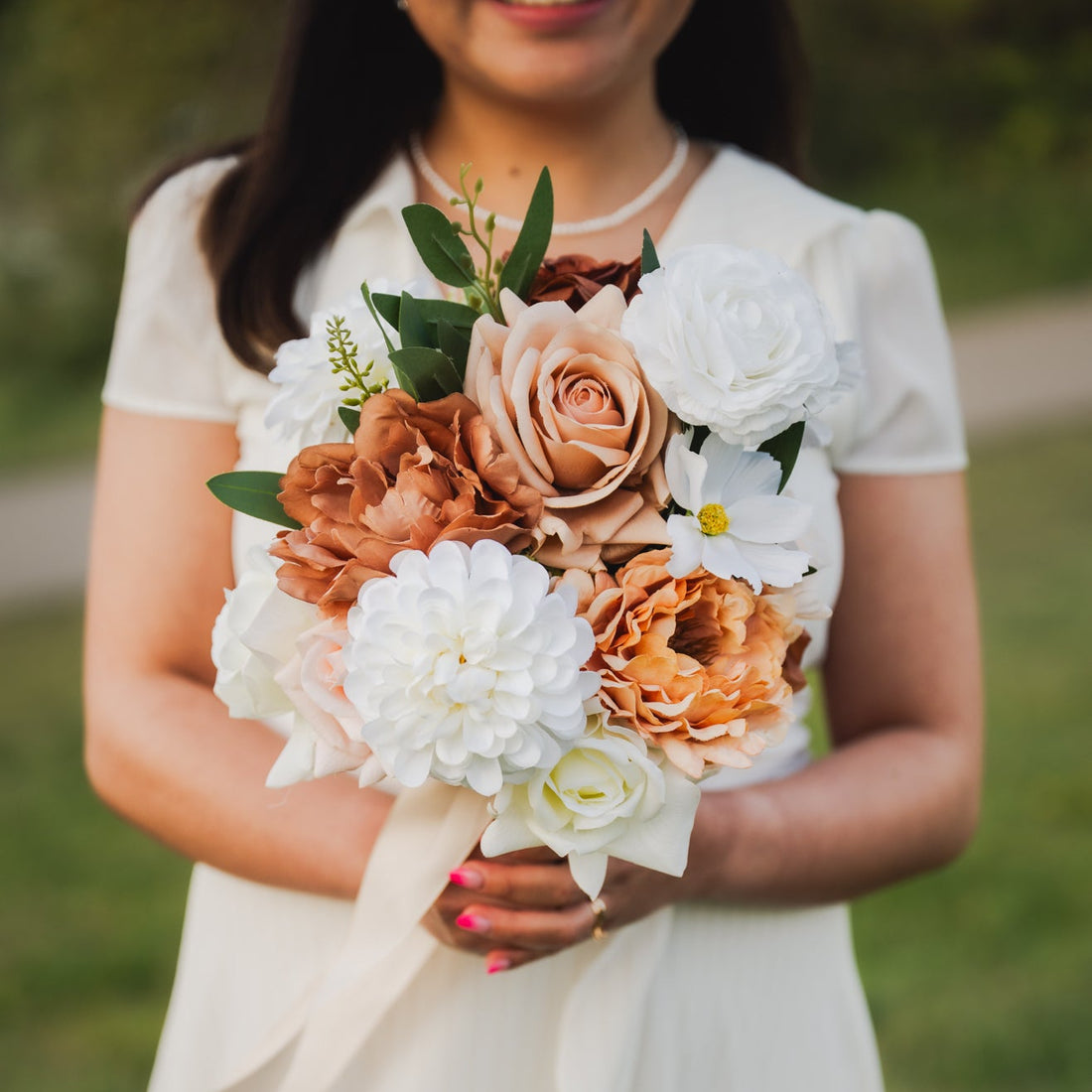 Model holding faux Cocoa Bloom bridesmaids bouquet with ivory, mocha, and blush artificial flowers — Edmonton wedding rentals