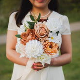 Model holding faux Cocoa Bloom bridesmaids bouquet with ivory, mocha, and blush artificial flowers — Edmonton wedding rentals