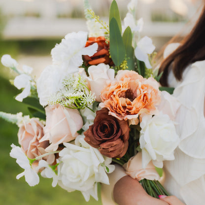 Close-up of artificial Cocoa Bloom bridal bouquet featuring real-touch flowers in cocoa brown, blush, ivory, and orange shades, tied with ribbon.