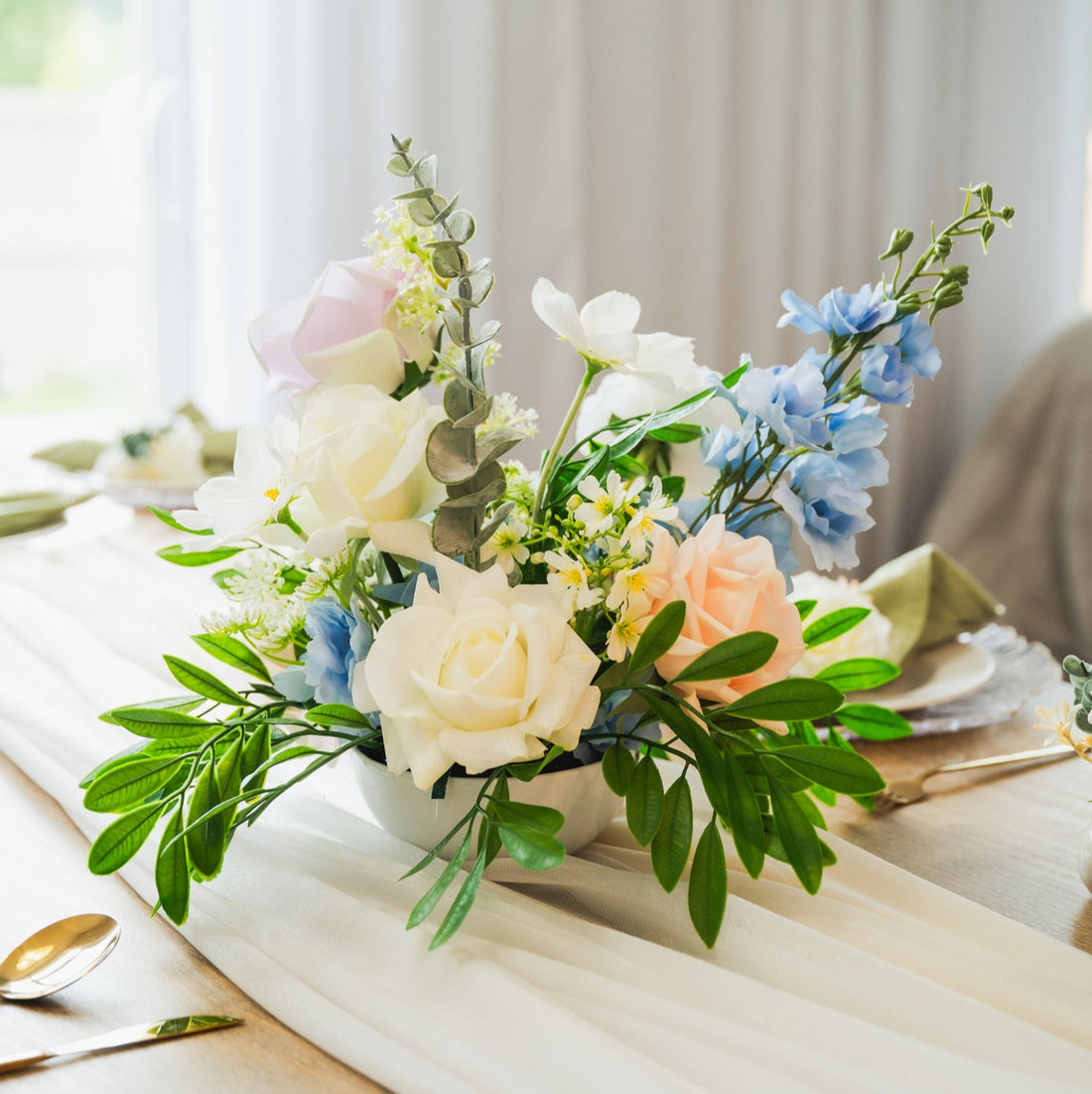 Pastel artificial wedding centerpiece with silk roses, faux hydrangea, and greenery on a guest table, Edmonton event rentals.