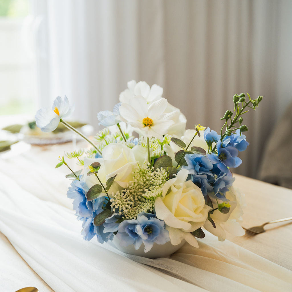 Ocean Breeze artificial flower arrangement on a table with white tablecloth and silverware.
