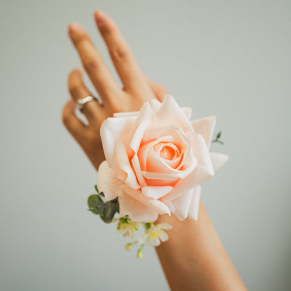 Artificial pastel petal corsage with blush rose and ivory accents worn on the wrist, faux wedding flowers rental in Edmonton.
