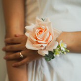 Close-up of faux blush rose wrist corsage with greenery, silk wedding corsage rental Edmonton for mothers or bridesmaids.