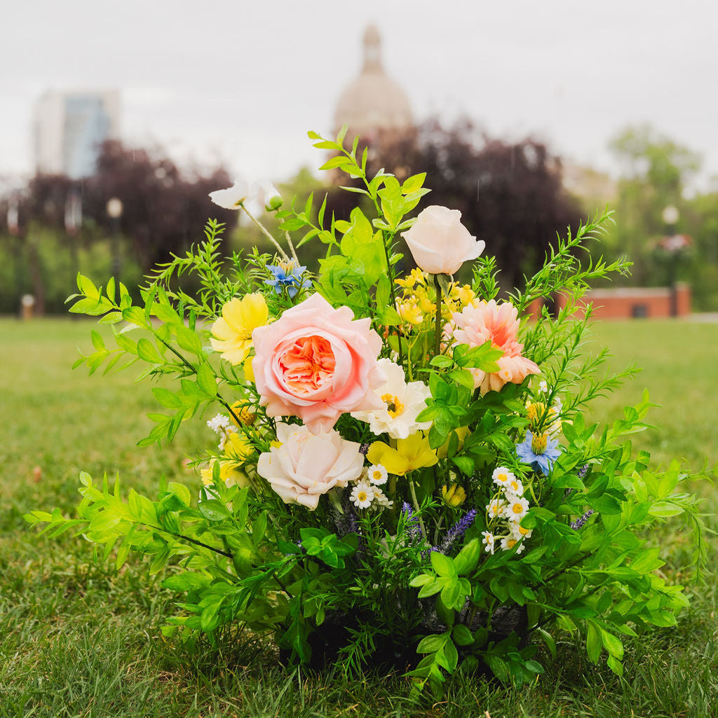 Close up shot of a Wildest Dreams floor floral arrangement (aisle marker) with a blurred background near the Alberta Legislature building. 