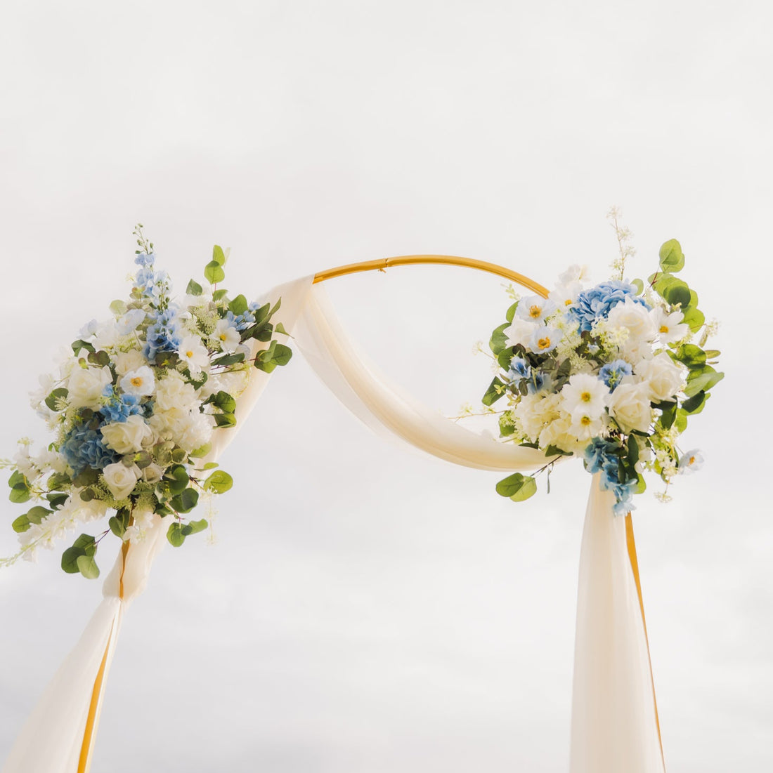 Decorative arch with floral arrangements against a clear sky