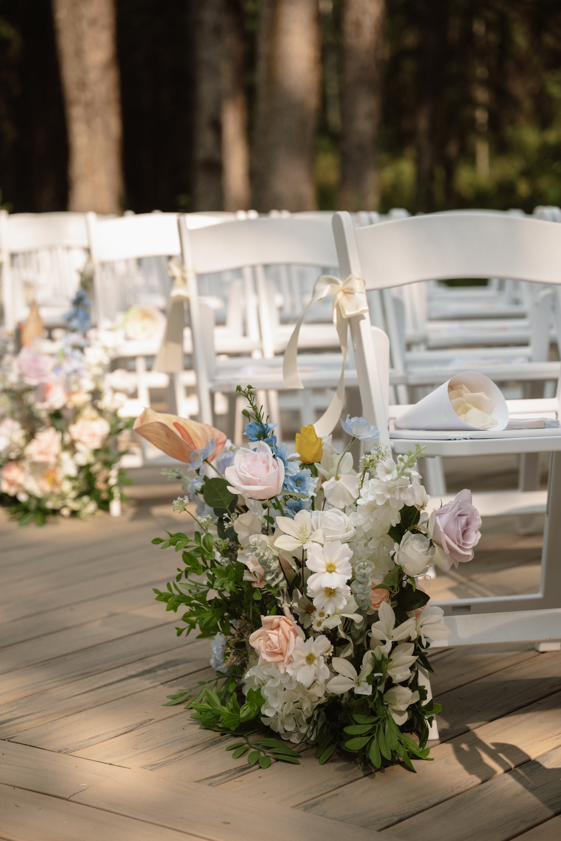 Decorative floral faux (silk and real touch) arrangement on a chair at an outdoor wedding ceremony in Red Deer.