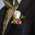 Real touch and silk groomsmen boutonniere on a dark suit jacket with a light shirt.